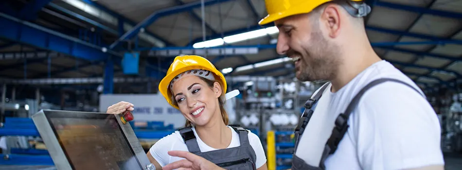 Due operai lavorano al computer che contiene un software dedicato alla Transizione 4.0 e al dialogo macchina-software